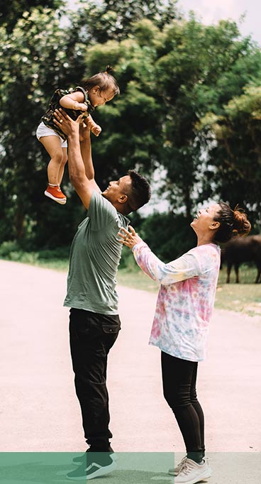 man holding baby next to wife