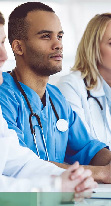 Successful medical doctors are smiling while sitting at the conference